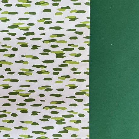 A roll of wrapping paper in painterly patterns and green in color.
