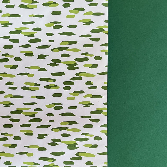 A roll of wrapping paper in painterly patterns and green in color.