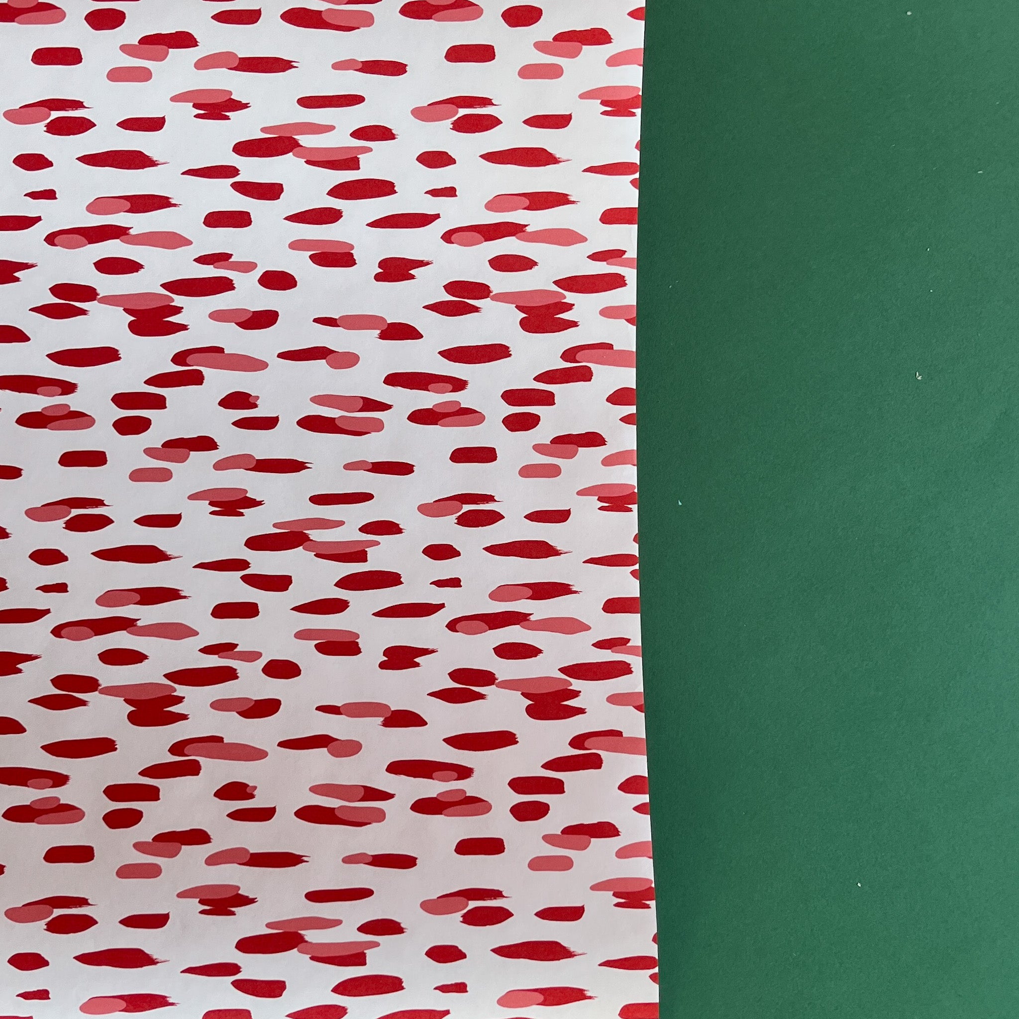 A roll of wrapping paper in painterly patterns and red in color.