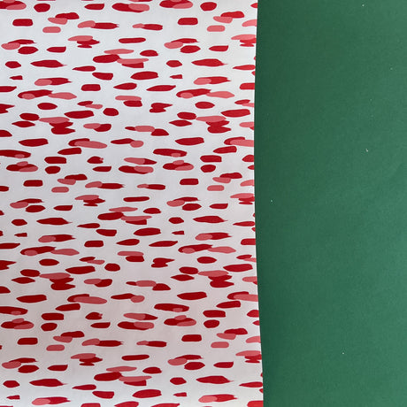 A roll of wrapping paper in painterly patterns and red in color.