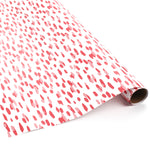 Roll of pink brushstroke wrapping paper on a white background.