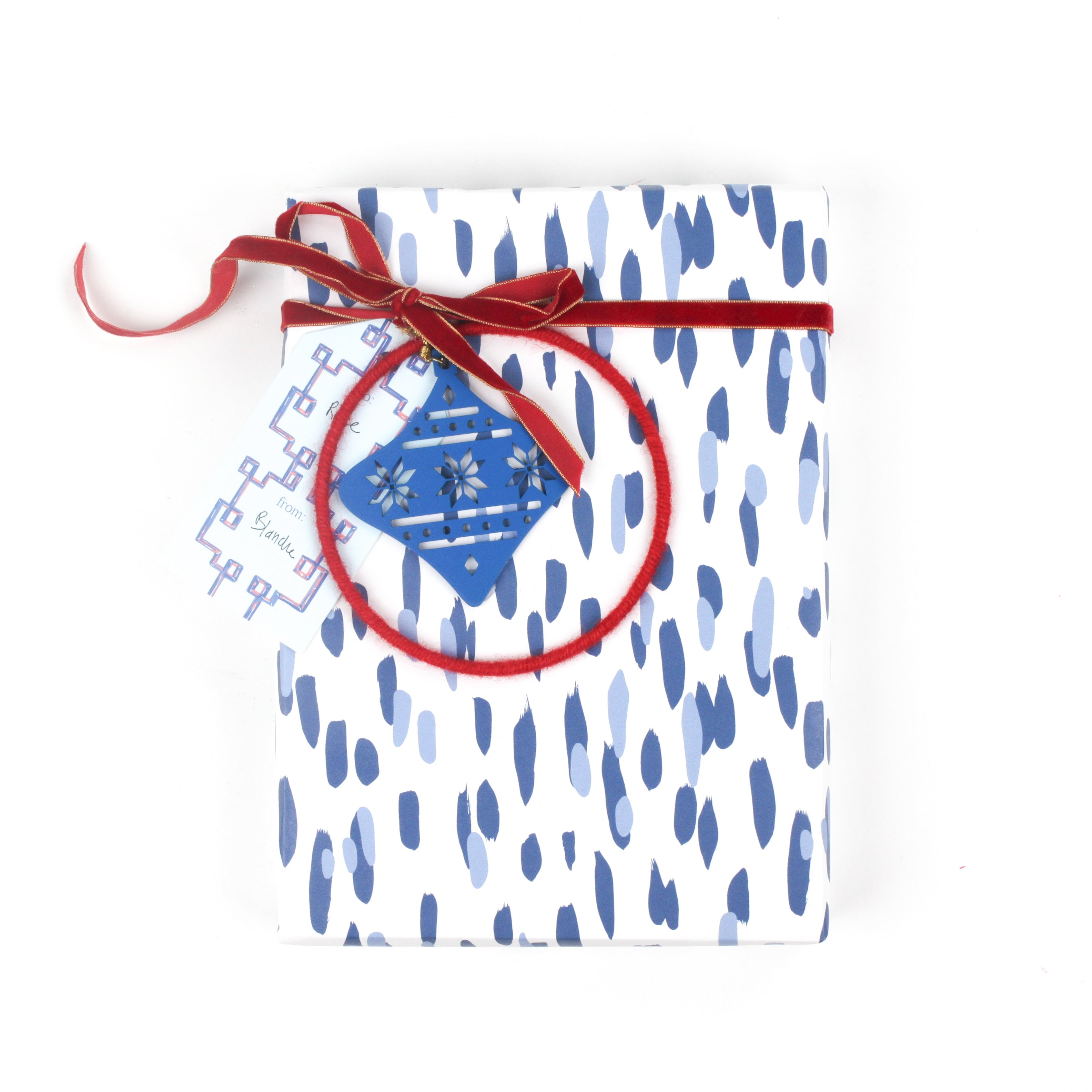 Gift wrapped in blue brushstroke wrapping paper with red ribbon and blue ornament tag.
