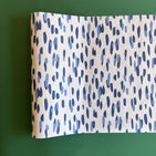 A blue and white paper table runner featuring a brushtroke pattern called Club House by Madcap Cottage