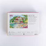 Coast of Italy 1000-piece jigsaw puzzle by Michael Storrings featuring a colorful illustrated Italian seaside village with beach umbrellas, swimmers, hillside houses, and vibrant summer scenery—box back view showing artwork description and puzzle details.