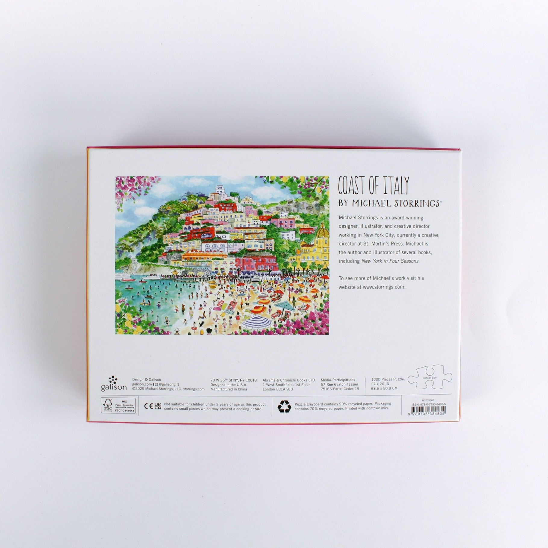 Coast of Italy 1000-piece jigsaw puzzle by Michael Storrings featuring a colorful illustrated Italian seaside village with beach umbrellas, swimmers, hillside houses, and vibrant summer scenery—box back view showing artwork description and puzzle details.