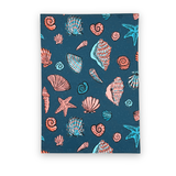 Folded coastal shell grotto tea towel with pink and turquoise seashell and starfish patterns.
