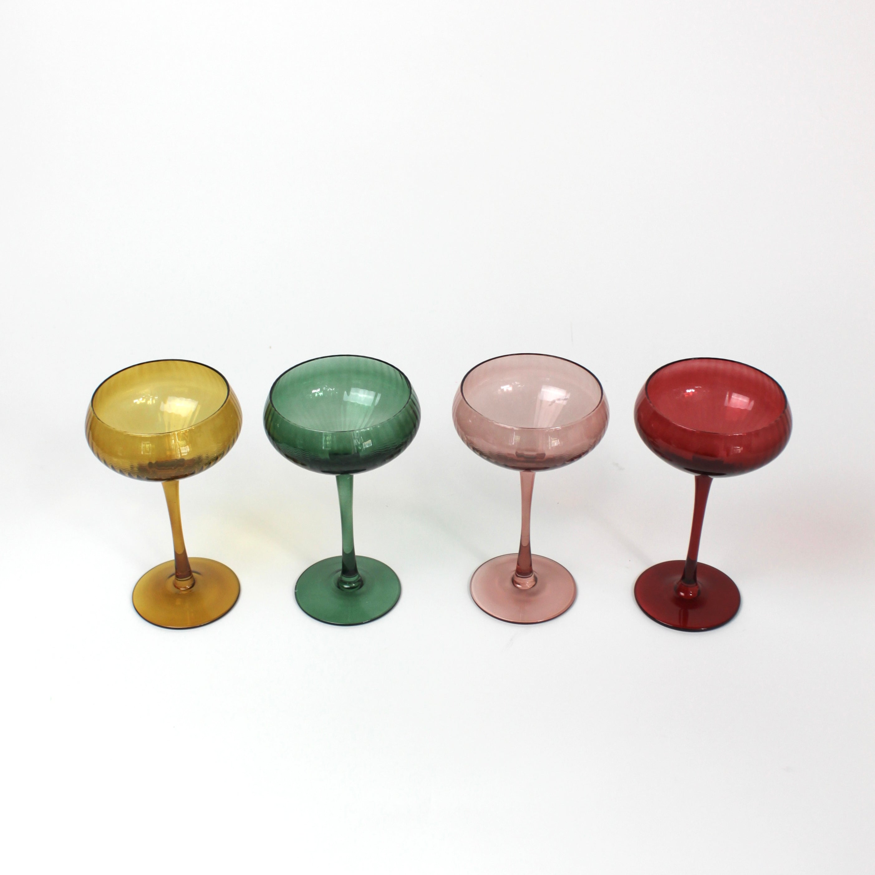 Four colorful cocktail glasses on a white background