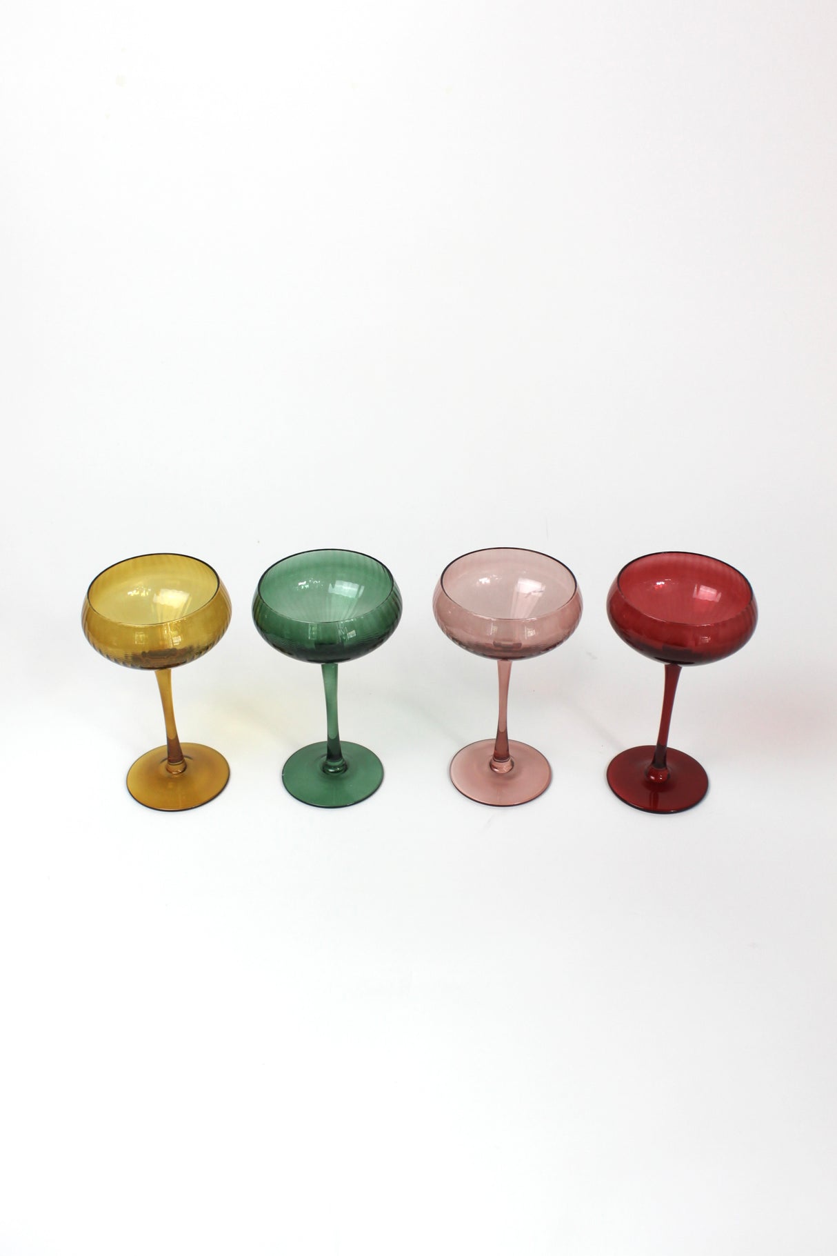 Four colorful cocktail glasses on a white background