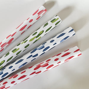 four paper table runners in pink, green, blue and red featuring a brushtroke  pattern by madcap cottage