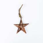 Copper star christmas ornament with brown and white pattern on a white background
