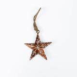 Copper star christmas ornament with brown and white pattern on a white background