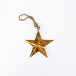 Gold star ornament with a string on a white background