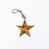 Gold star ornament with a string on a white background