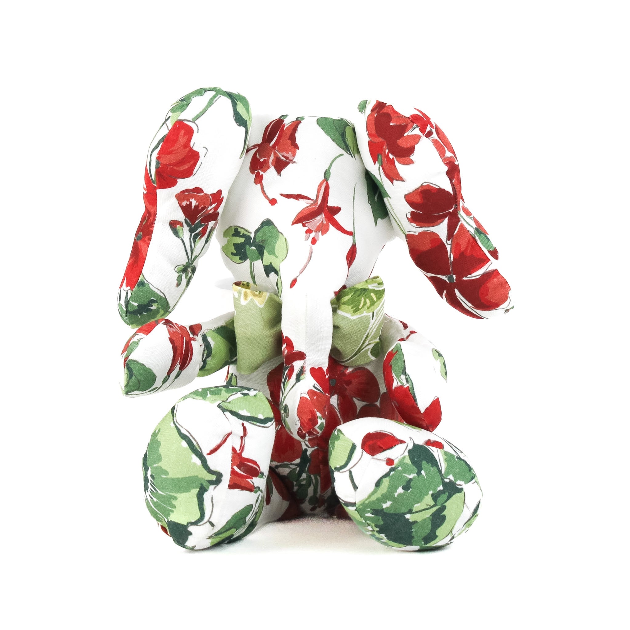 White stuffed elephant toy with red and green floral pattern and green bow.
