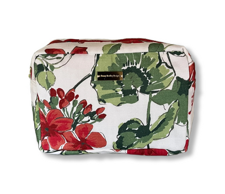 Cottage Grove Geranium is a floral toiletries bag with a red, green, and white color scheme, featuring a geranium design.