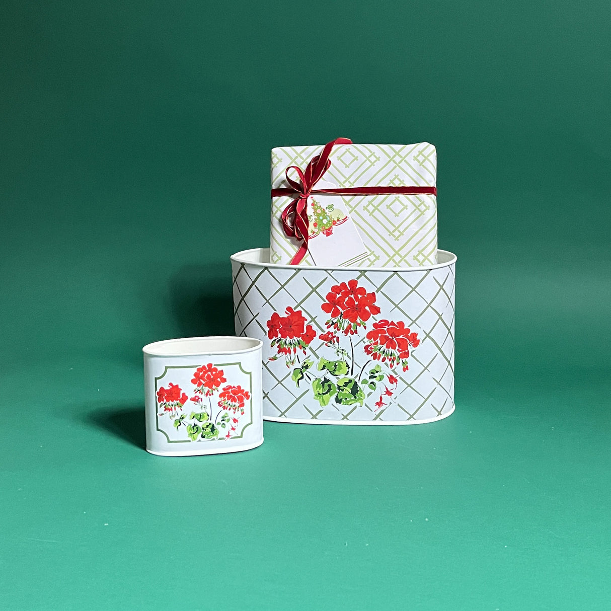 Cottage Grove Geranium filled duo of red caddies in large and small on a green background