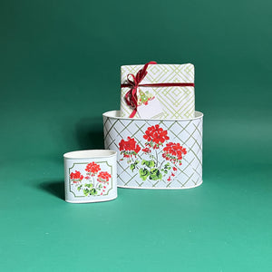 Cottage Grove Geranium filled duo of red caddies in large and small on a green background