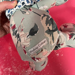 Close-up of a
Floral patterned stuffed elephant toy with a blue and white bow.