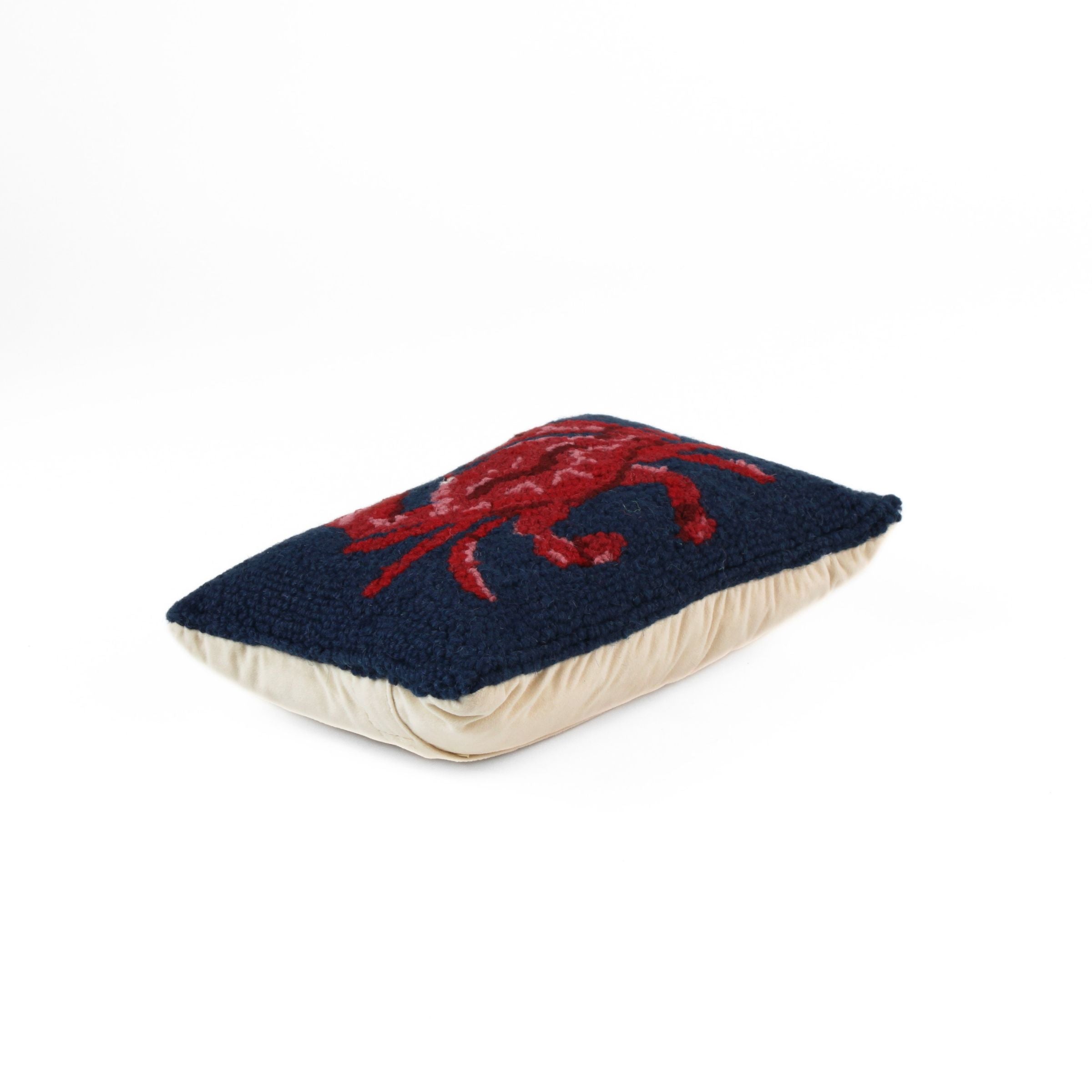 Red and blue crab throw pillow side view with navy textured fabric and beige backing.