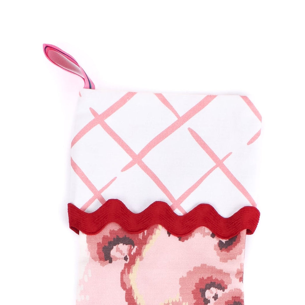 pink christmas stocking with latttice pattern on a white background