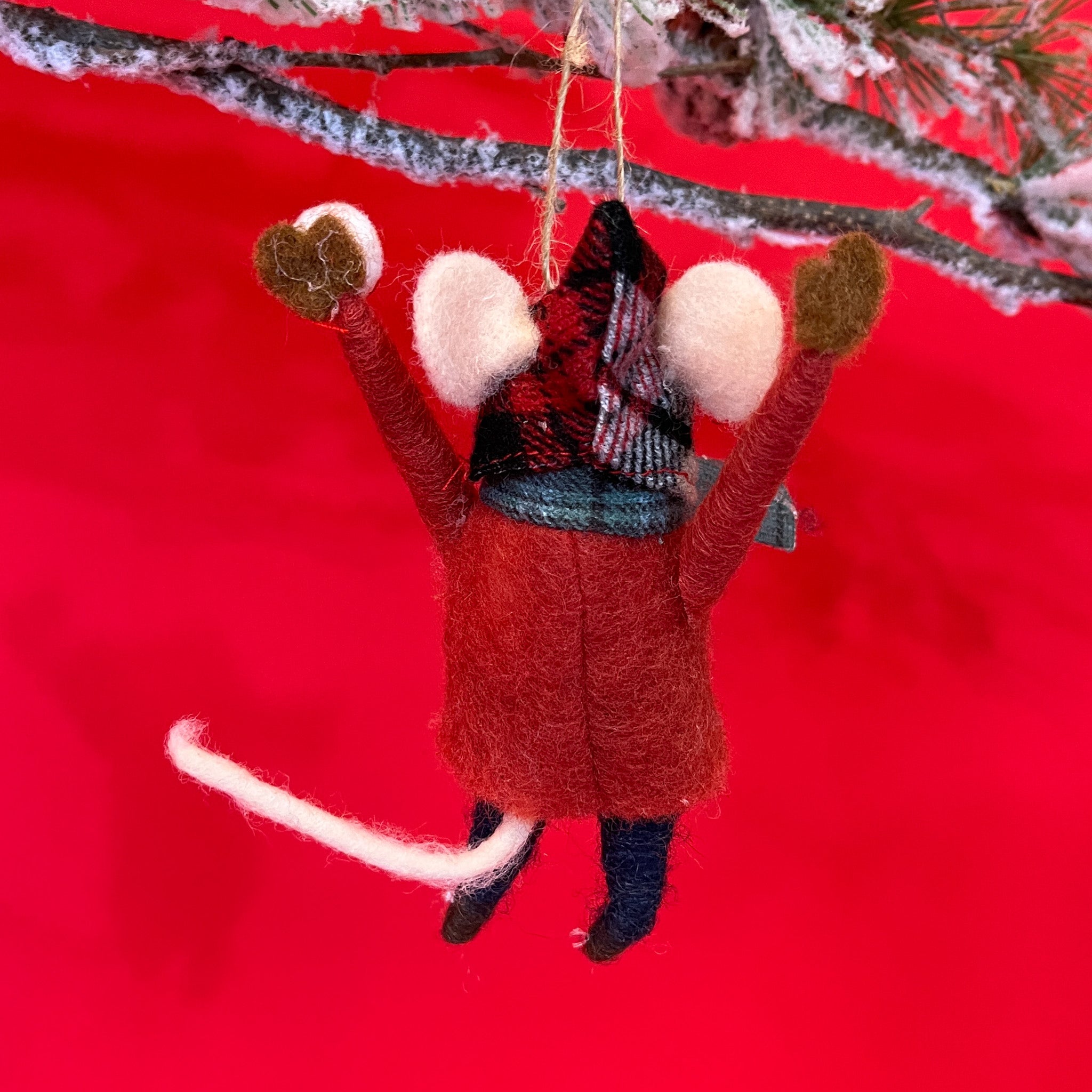 back of Cute felt mice ornament wearing a red sweater and grey scarf against a red background.