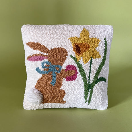 a white bunny pillow featuring a brown bunny and yellow daffodil