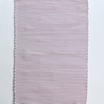 the plain reverse side of a pink accent rug