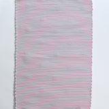 the plain reverse side of a pink accent rug