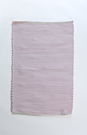 the plain reverse side of a pink accent rug