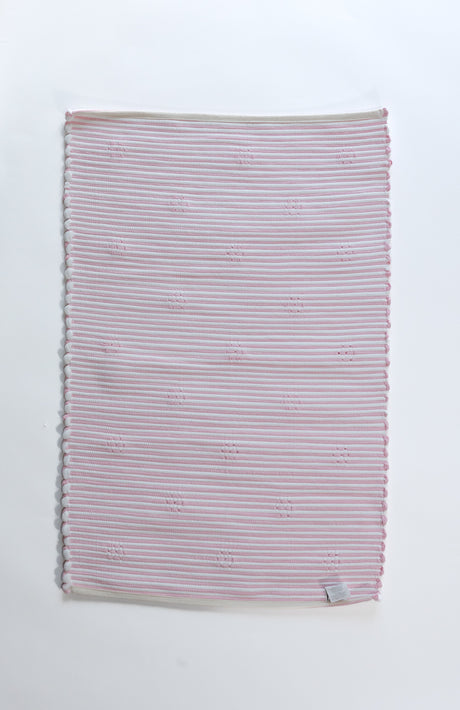 the plain reverse side of a pink accent rug