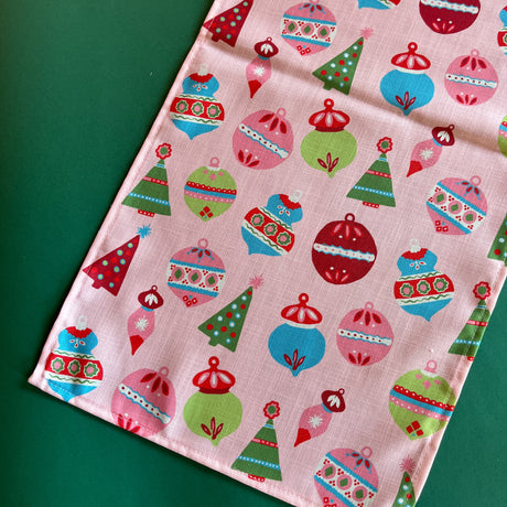 Darling Ornaments Christmas Cloth Table Runner on a green background