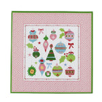 square pink paper placemats with colourful ornaments motifs in the center surrounded by a pink and green border. 