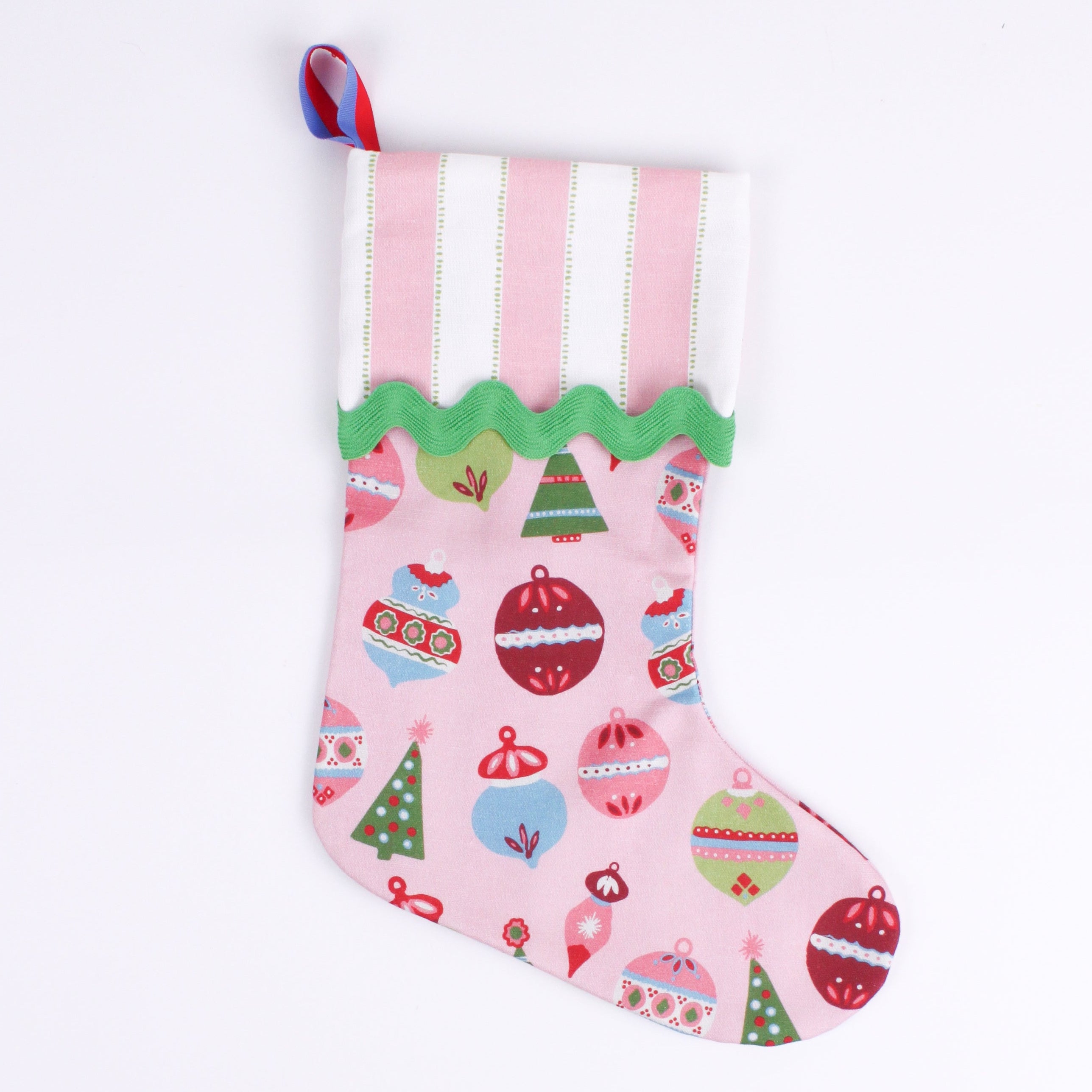A pink Christmas stocking patterned with colorful ornaments on a white background