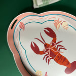 a tole metal serving tray with a rock lobster motif with cut-out handles