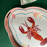 a tole metal serving tray with a rock lobster motif with cut-out handles