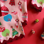 Detail view of our Darling Ornaments Christmas cloth dinner napkins with red ric rac trim on a red background with glas ball ornaments.