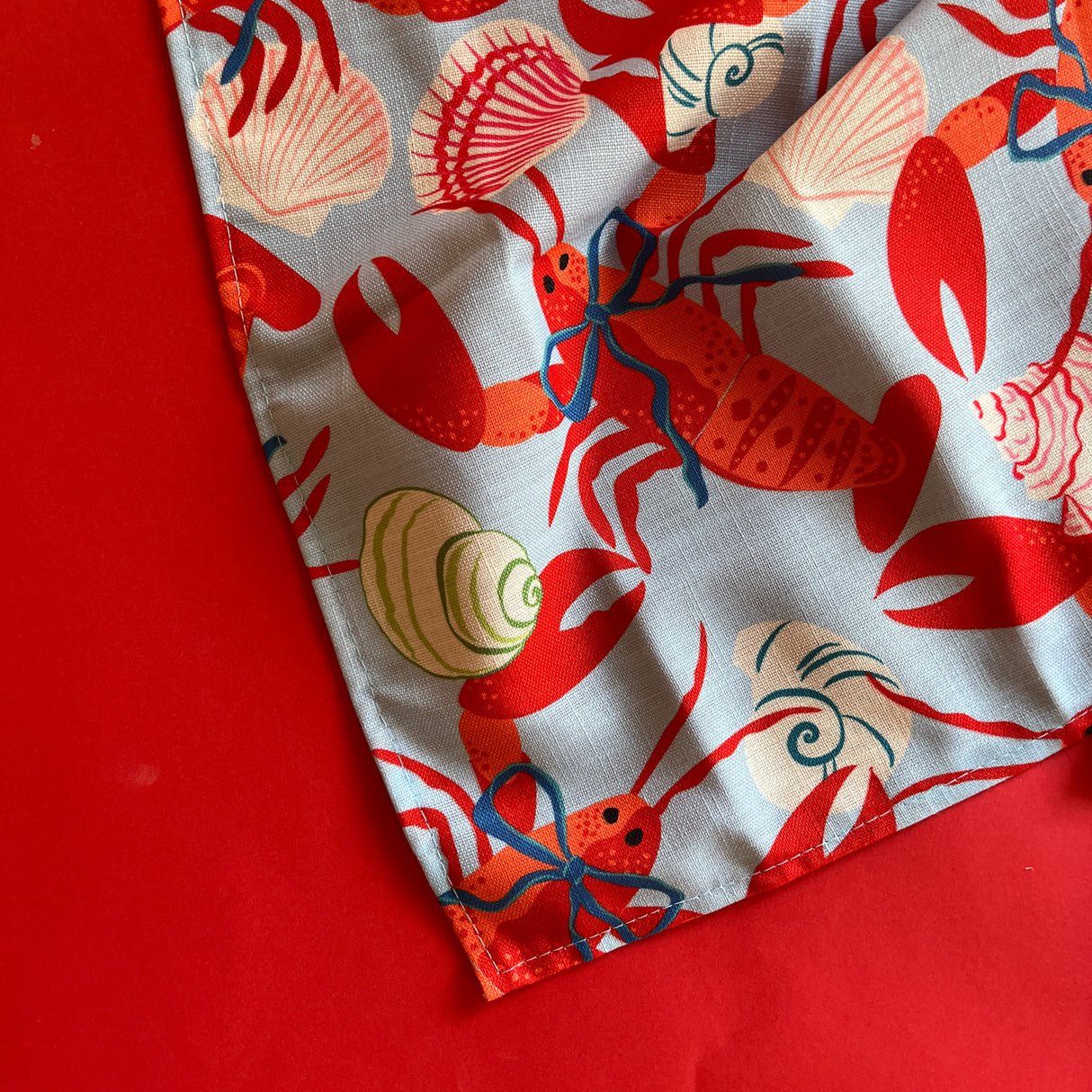 A detailed view of red rock lobsters on blue cloth dinner napkins