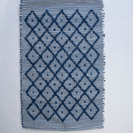 A cotton blue accent rug with a repeating diamond motif from Madcap Cottage. 