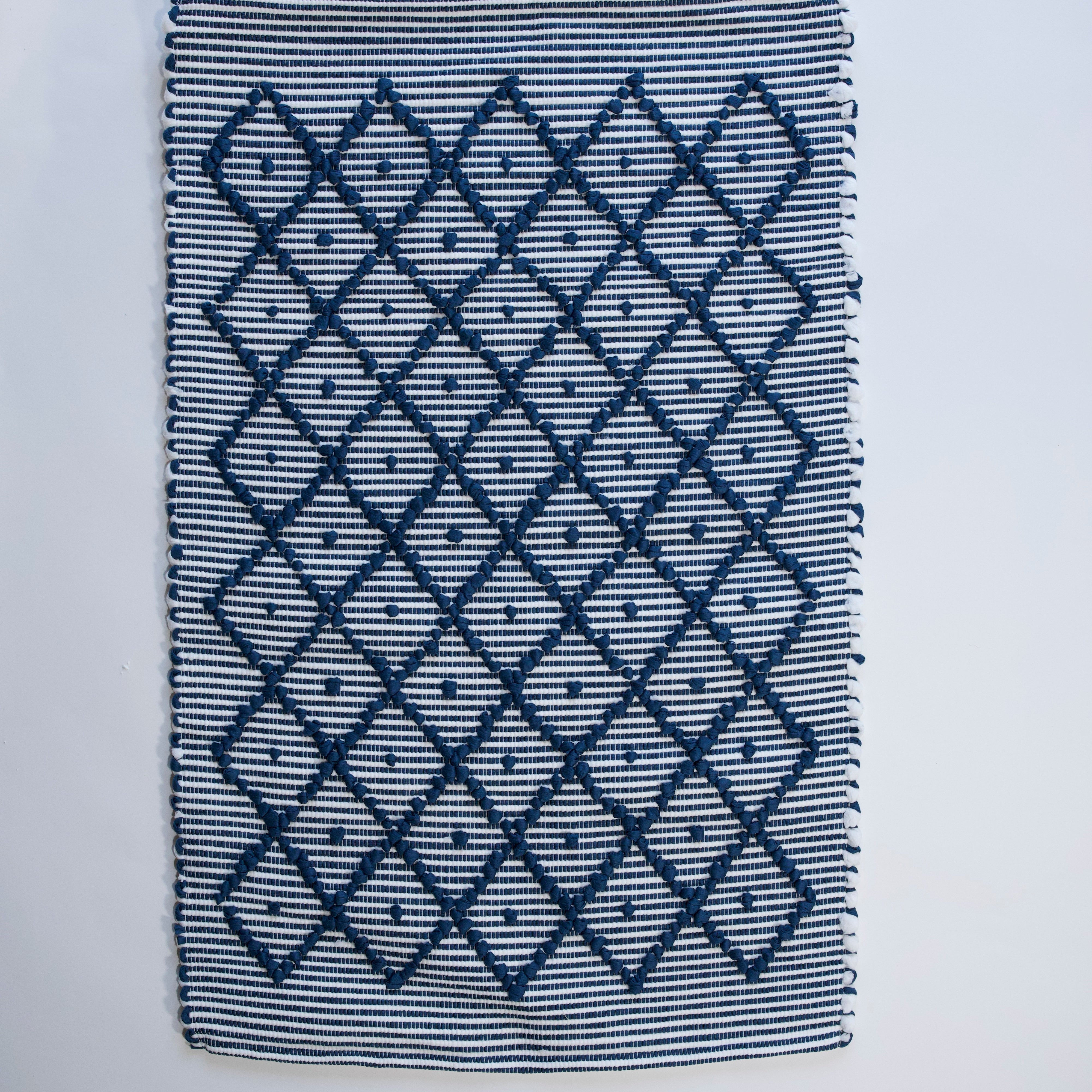 A cotton blue accent rug with a repeating diamond motif from Madcap Cottage. 