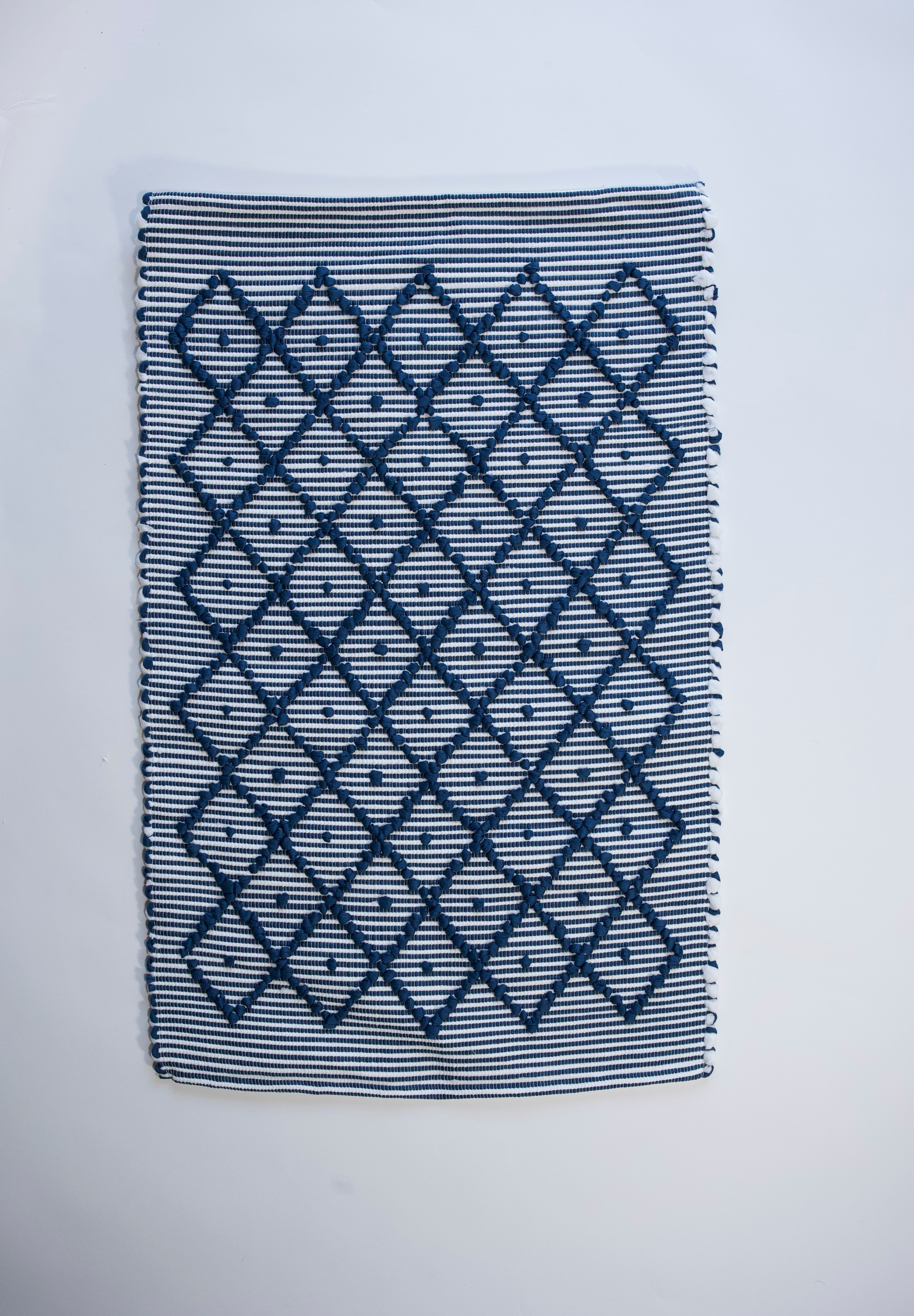 A cotton blue accent rug with a repeating diamond motif from Madcap Cottage. 