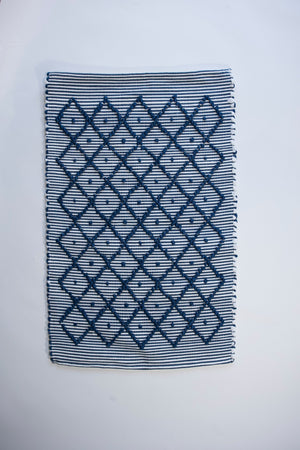 A cotton blue accent rug with a repeating diamond motif from Madcap Cottage. 