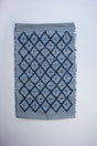 A cotton blue accent rug with a repeating diamond motif from Madcap Cottage. 