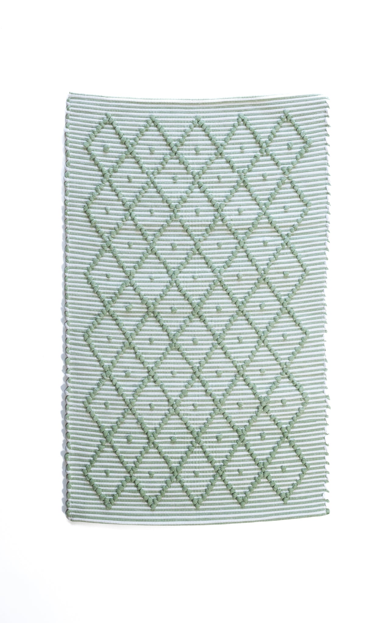 A Madcap Cottage green accent rug with a diamond pattern on the front 