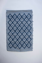 A cotton blue accent rug with a repeating diamond motif from Madcap Cottage. 