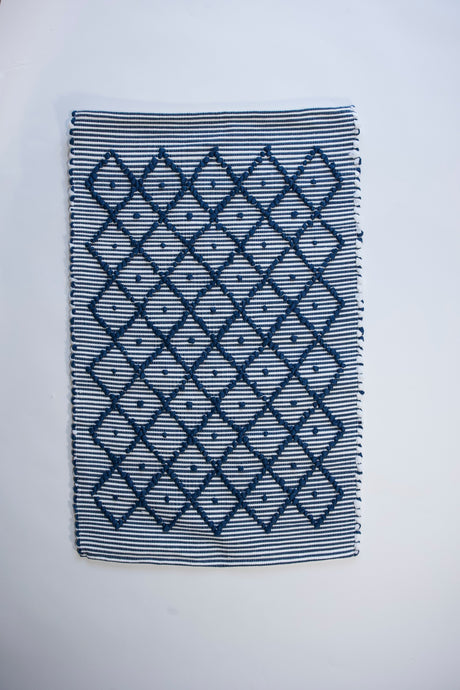 A cotton blue accent rug with a repeating diamond motif from Madcap Cottage. 