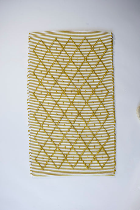 A cotton yellow accent rug with a repeating diamond motif from Madcap Cottage. 