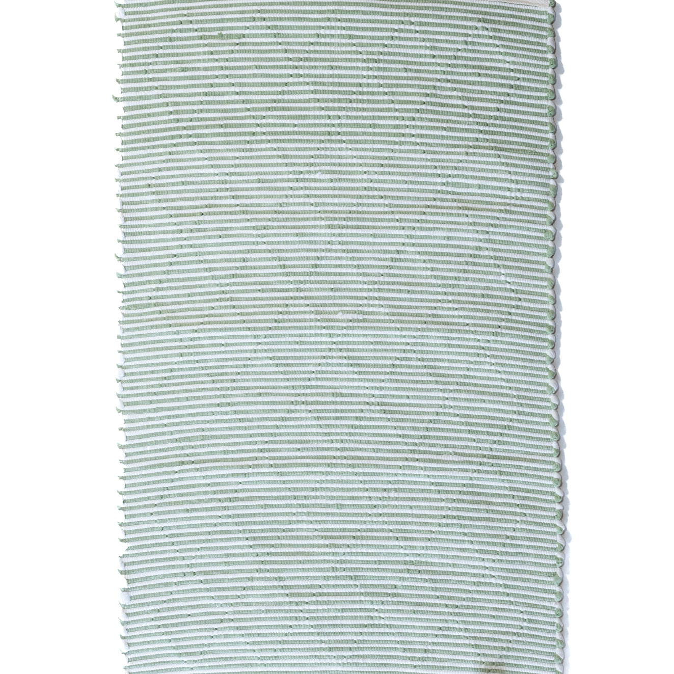 the reverse side of a cotton green accent rug 