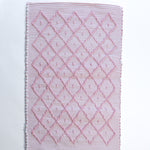 A madcap cottage cotton pink accent rug with a diamond pattern on the front 