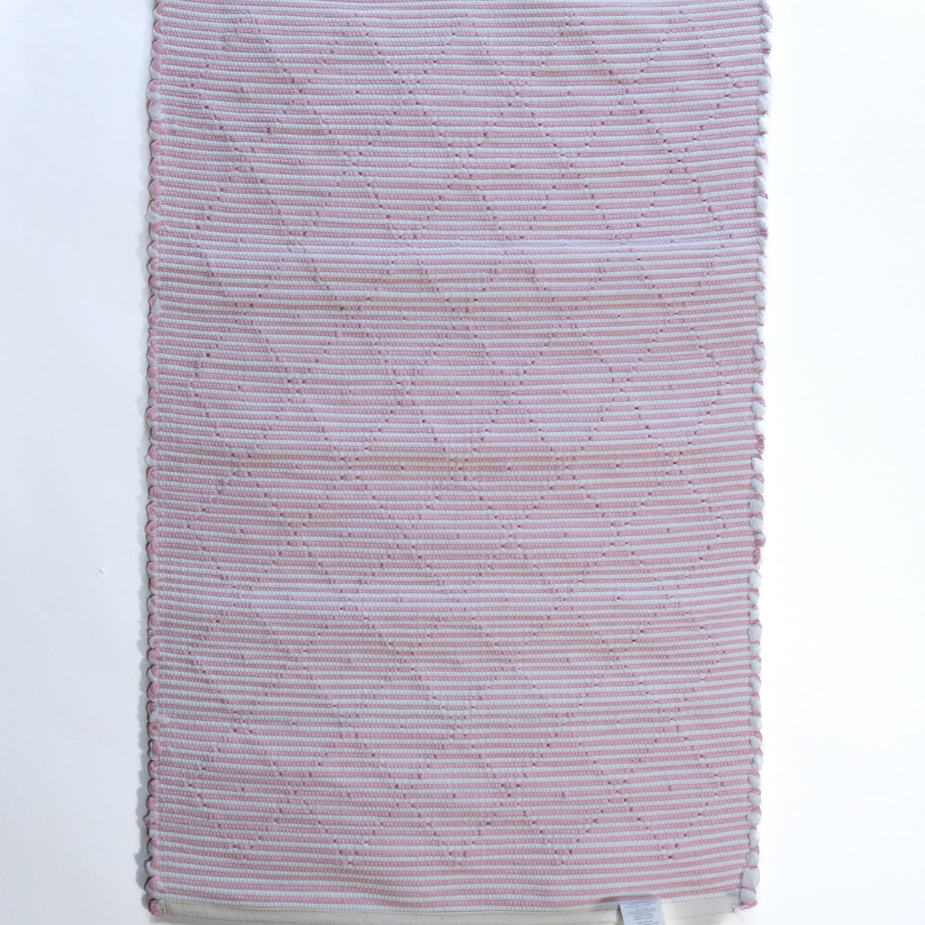 The plain reverse side of a pink accent rug from madcap cottage
