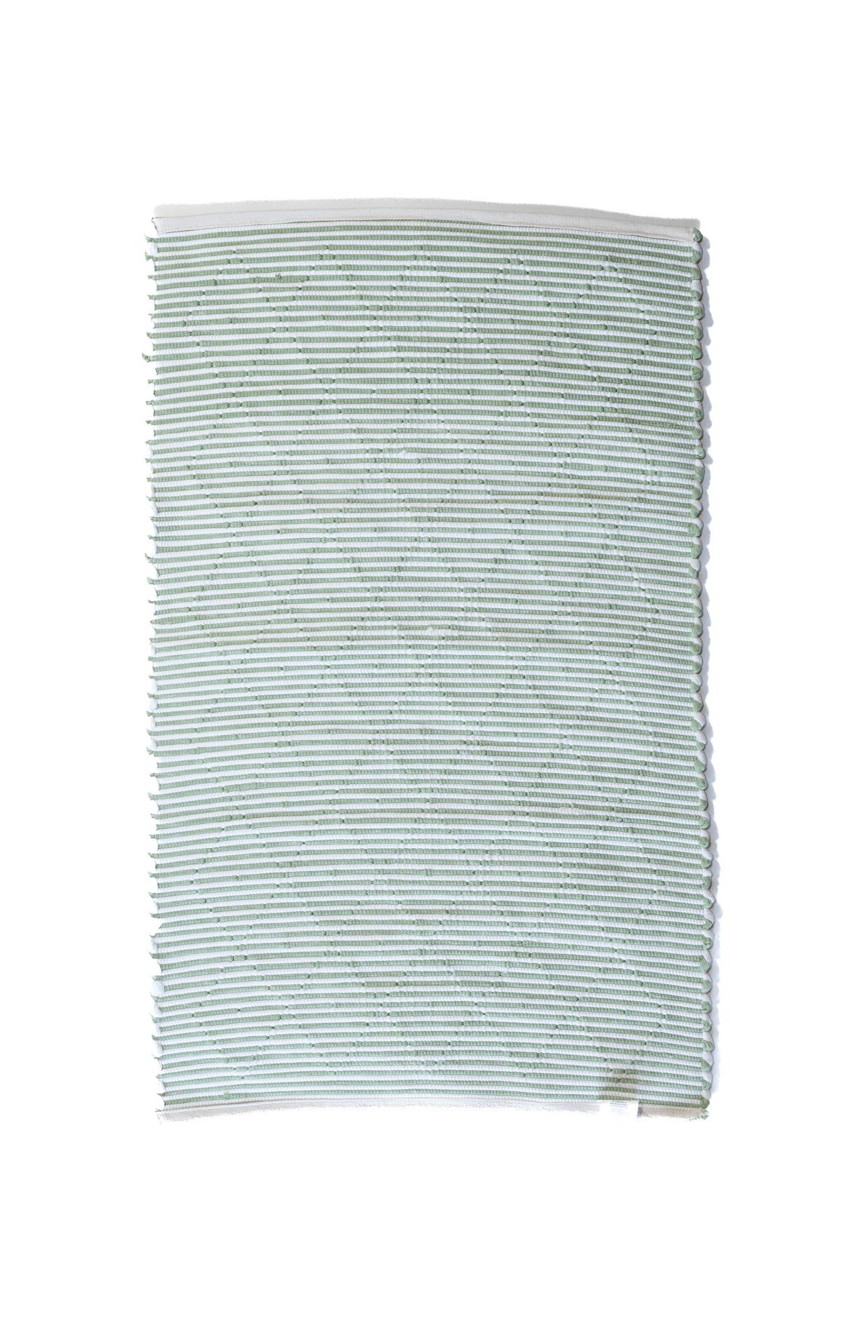the reverse side of a cotton green accent rug 